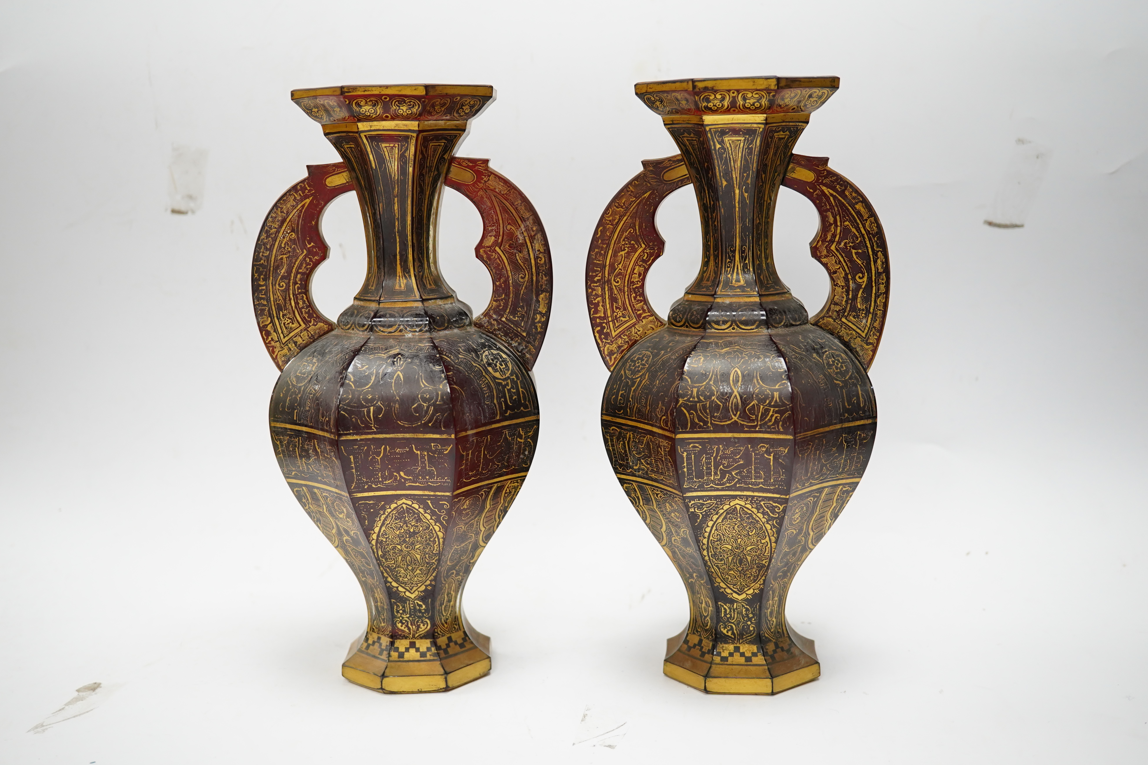 A pair of Venetian Islamic inspired gilt decorated ruby glass twin handled vases, 24cm high. Condition - wear to gilding on both vases